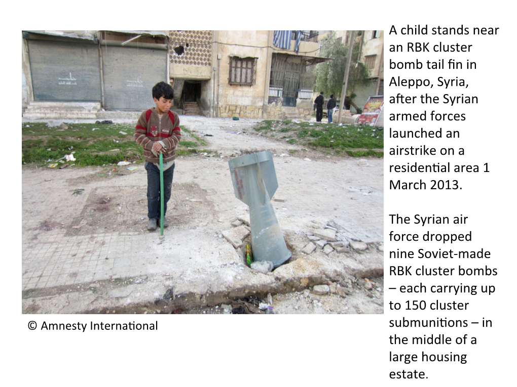 A Child Stands Near an RBK Cluster Bomb Tail Fin in Aleppo, Syria, After